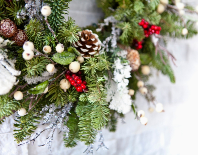 A close up of a Christmas wreath on a stone wall