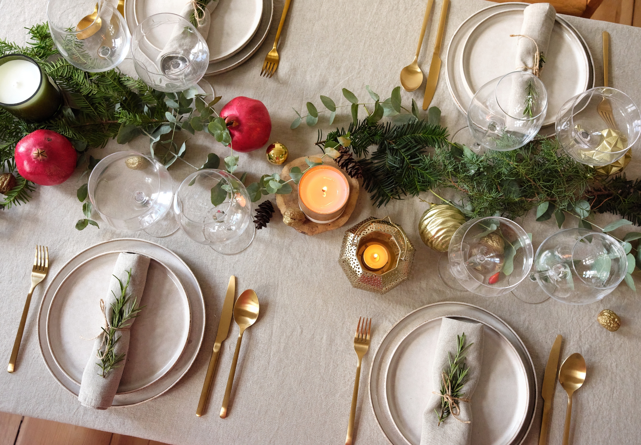 A dinner table set with gold and green decorations