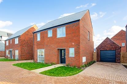 A red brick detached house with a garage and brick driveway