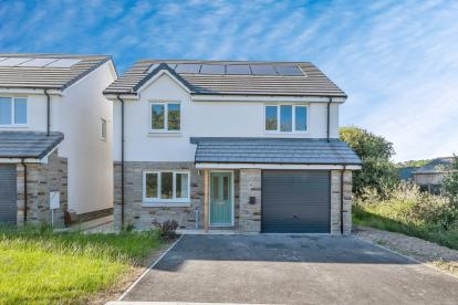 a two-storey home with white render and grey brickwork and a grey tiled roof. The property has a garage and driveway