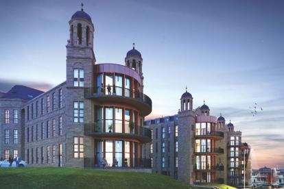 Twilight view of The Nightingale residential development with stone façades, curved balconies and illuminated apartments.