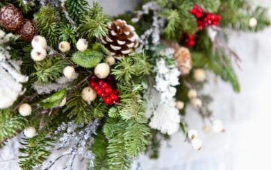 A close up of a Christmas wreath on a stone wall