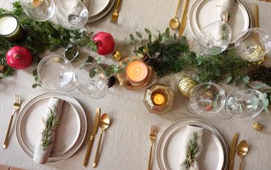 A dinner table set with gold and green decorations