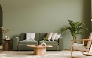 ere’s a short alt text for the image:  "Modern living room with green sofa, wooden coffee table, armchair, and large potted plant against a green wall