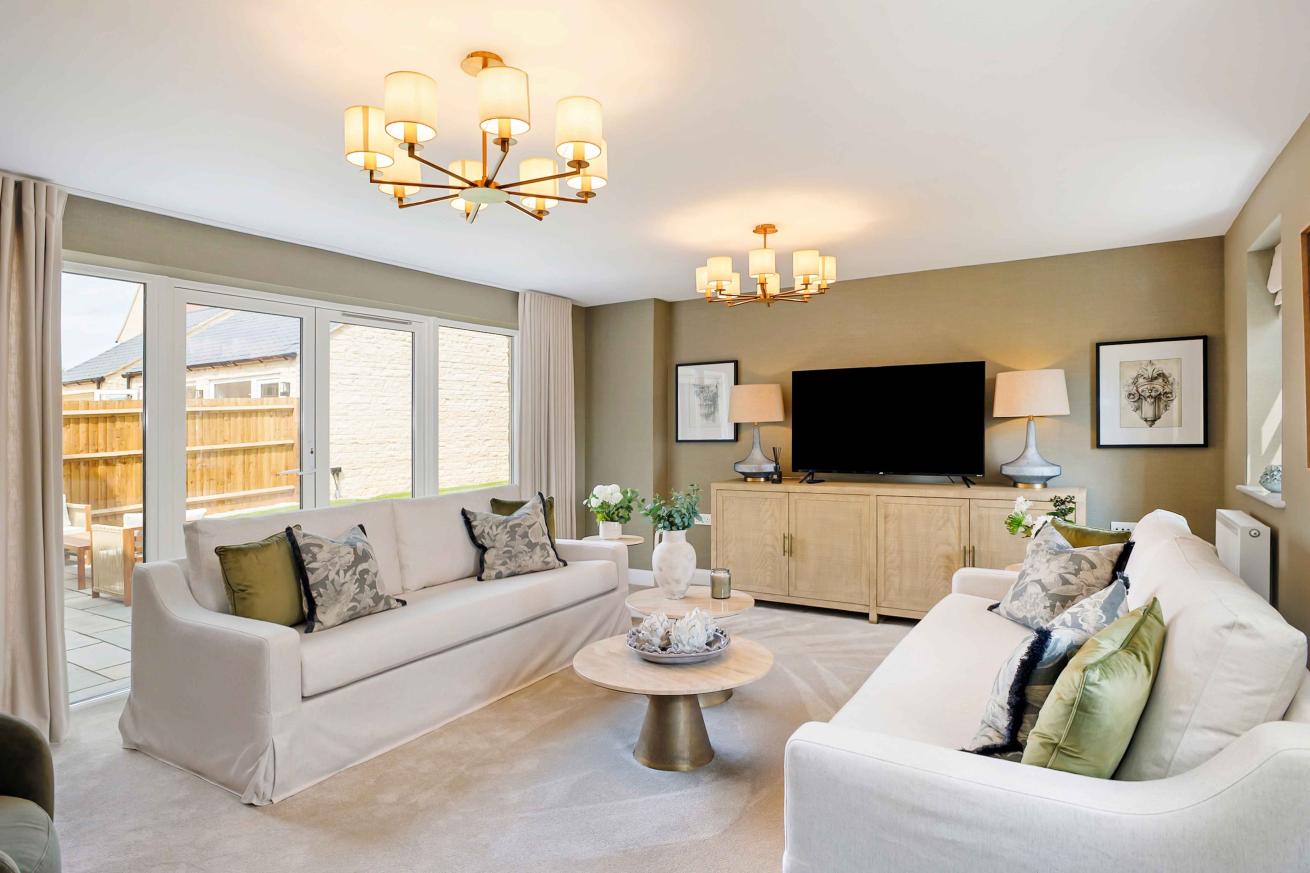 Cozy living room finished with cream carpet, sofas and a wooden TV unit. 