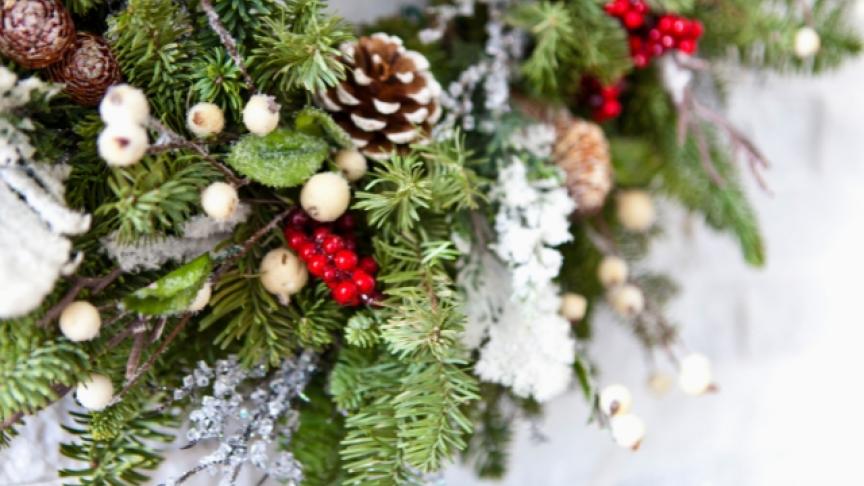 A close up of a Christmas wreath on a stone wall