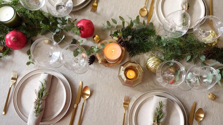 A dinner table set with gold and green decorations