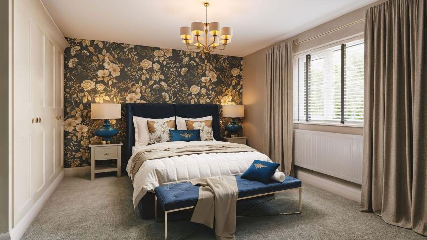 A stylish bedroom with an upholstered bed, floral feature wall, blue accents, bedside tables, and a window with open curtains.